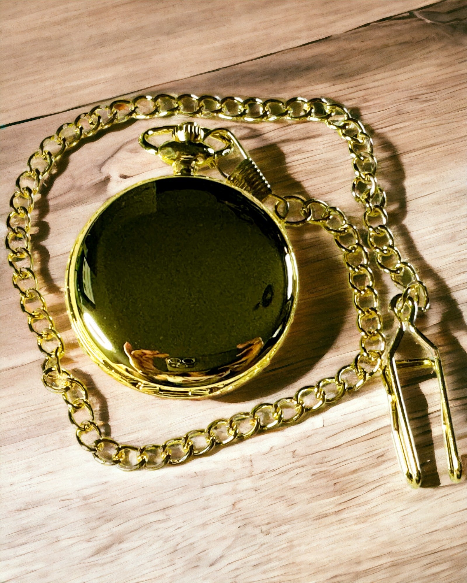 Kaiverruksella varustettu kultainen taskukello