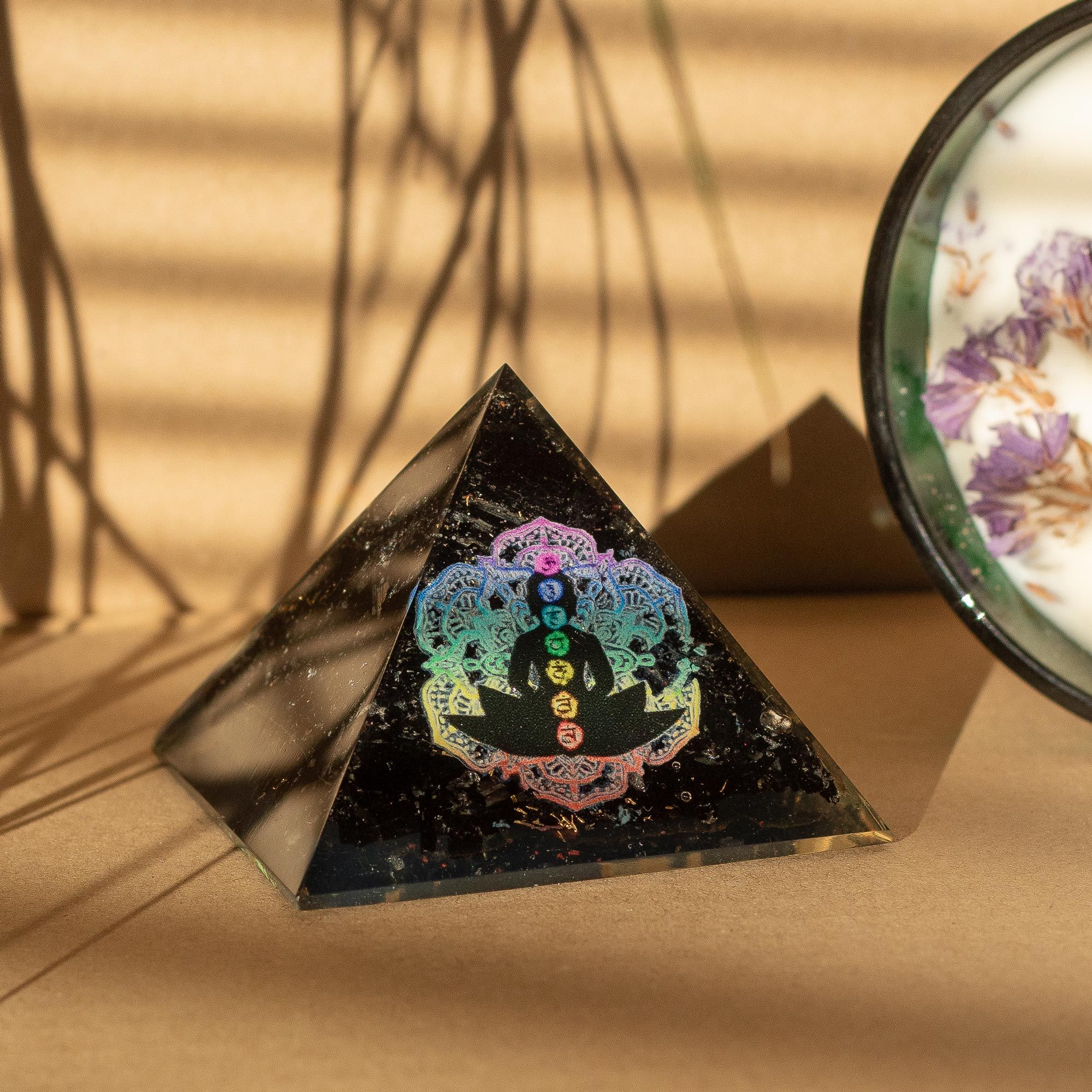 Pieni orgaaninen pyramidi mustasta turmaliinista 5,5x4,5 cm buddhan chakrojen motiivilla