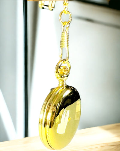 Kaiverruksella varustettu kultainen taskukello