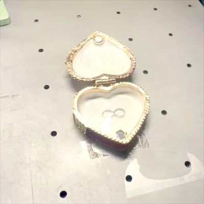 Metallinen sydämen muotoinen korurasia, jossa kristallit, punakulta-hopea, mahdollisuus personointiin kaiverruksella, täydellinen romanttiseksi lahjaksi, mitat 4,8 x 4 x 2,5 cm